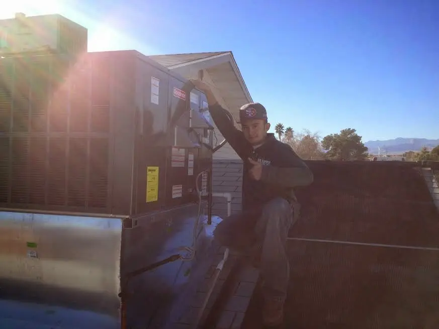HVAC technician performing HVAC Inspection on a rooftop unit in Watford City